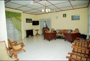 a living room with chairs and a couch and a television at Green Shadow Inn in Galle