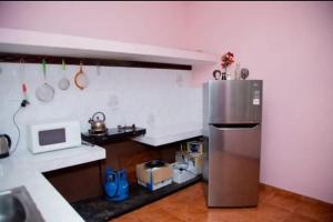 a kitchen with a stainless steel refrigerator and a microwave at Green Shadow Inn in Galle