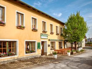 a building with benches and flowers in front of it at Dobersbergerhof in Dobersberg +23 photos