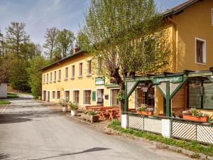 a yellow building with tables and benches next to a street at Dobersbergerhof in Dobersberg