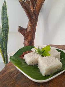 a plate of sushi on top of a green leaf at Sunshine Holiday Inn Ella in Ella