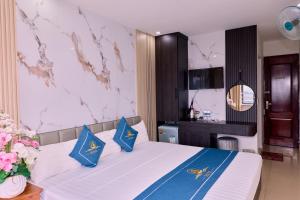 a bedroom with a large bed with blue pillows at Cat Ba Bay Vision Hotel in Cat Ba