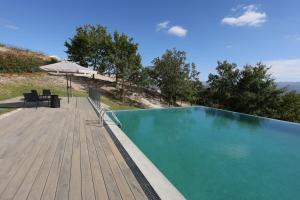 a swimming pool with a deck and an umbrella at Quinta do Giz in Baião