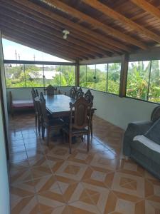 ein Esszimmer mit Tisch, Stühlen und Sofa in der Unterkunft Refúgio Madá in Florianópolis
