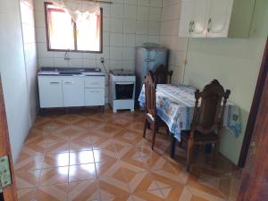eine Küche mit Tisch, Stühlen und Kühlschrank in der Unterkunft Refúgio Madá in Florianópolis