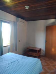 ein Schlafzimmer mit einem Bett und einer Holzdecke in der Unterkunft Refúgio Madá in Florianópolis