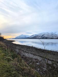 a body of water with snow covered mountains in the background at The Hideaway Guest suite in Fort William