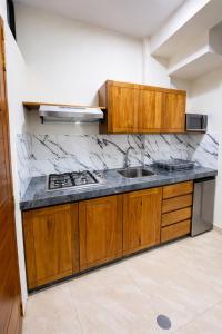 a kitchen with wooden cabinets and a sink at studio confort in Iquitos
