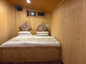 a wooden room with a bed in a wooden wall at Favela Headrooms in Srinagar