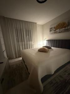 a bedroom with a large white bed and a window at Barney Apartman in Sovata