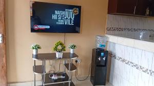 a counter with a table and a tv on a wall at Breezes home Bamburi in Bamburi +3 photos