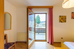 a room with a sliding glass door with a balcony at Residence Lenzenau in Tirolo