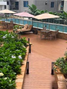 a wooden deck with tables and chairs and a swimming pool at The Nestle & The Cradle - Kileleshwa in Nairobi