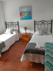 ein Schlafzimmer mit zwei Betten und einem Tisch mit Lampe in der Unterkunft Chalet Kuki in Ribas + 14 Fotos