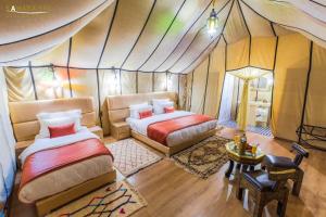 a bedroom with two beds in a tent at Erg Chebbi Traditional Experience & Activities in Merzouga