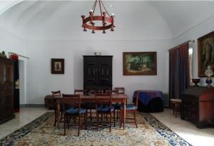 a dining room with a table and chairs and a chandelier at Casa da Lagoa Guest House in Évora