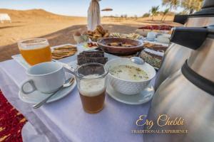 a table with food and two glasses of beer at Erg Chebbi Traditional Experience & Activities in Merzouga +41 photos