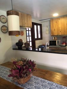a kitchen with a basket of flowers on the floor at Chalé Refidim in Gravatá