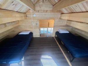 a room with two beds in a wooden cabin at Horseshoe Lake Beachside Cottage in Parry Sound +5 photos