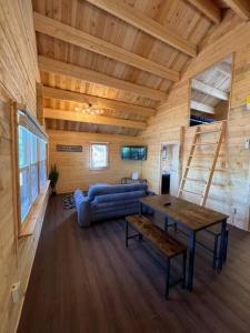a living room with a blue couch and a table at Horseshoe Lake Beachside Cottage in Parry Sound