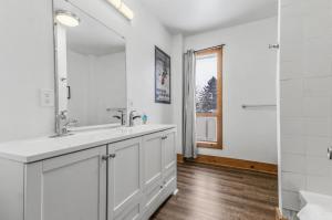 a white bathroom with two sinks and a mirror at Mountain Trail-Smart TV-Self Check-In-Full Kitchen-Balcony-BBQ in Blue Mountains