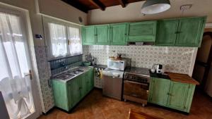 a green kitchen with green cabinets and a sink at Da' Mi ' Nonni in Viareggio +22 photos