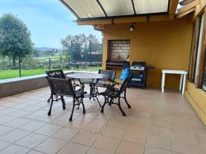 a patio with a table and chairs and a stove at Casa Campestre Arama in Paipa