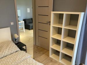 a bedroom with a bed and a closet with shelves at Cisy Resort-idealny dla gości ze zwięrzętami,ogrodzony teren na wyłączność,150 m od jeziora in Makosieje