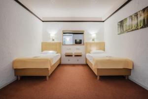a room with two beds and a tv in it at CONTEL Hotel in Koblenz