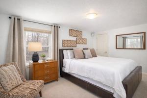 a bedroom with a bed and a chair and a window at Private Riverside Retreat in Appleton