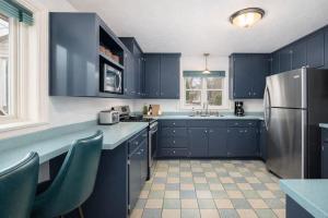 a kitchen with blue cabinets and a stainless steel refrigerator at Private Riverside Retreat in Appleton
