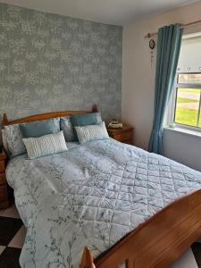 a bedroom with a large bed with blue curtains at Notre Petit Chateau in Rosslare Harbour