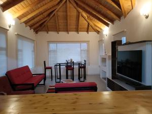 a living room with a table and chairs and a television at Casa Campestre Arama in Paipa