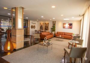 a living room with orange couches and tables at Hotel Dan Inn Express Ribeirão Preto By Nacional Inn in Ribeirão Preto