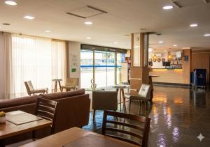 a restaurant with tables and chairs and a lobby at Hotel Dan Inn Express Ribeirão Preto By Nacional Inn in Ribeirão Preto