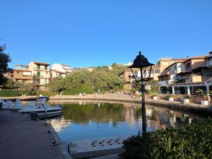a street light next to a body of water with buildings at Sardinia Re - Grecale 25 in Porto Rotondo