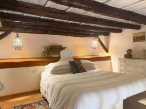 a bedroom with a white bed in a room with beams at Camidù Boutique House in Palermo