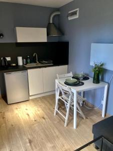 a small kitchen with a white table and chairs at Cisy Resort-idealny dla gości ze zwięrzętami,ogrodzony teren na wyłączność,150 m od jeziora in Makosieje