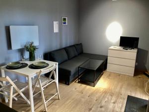 a small living room with a couch and a table at Cisy Resort-idealny dla gości ze zwięrzętami,ogrodzony teren na wyłączność,150 m od jeziora in Makosieje