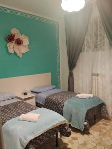 two beds in a room with green walls at Casa di Ana 2 affittacamere in Ancona