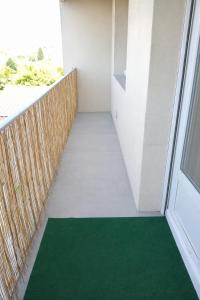 a balcony with a green floor and a window at Le Candy- Appartement de charme à Digoin in Digoin