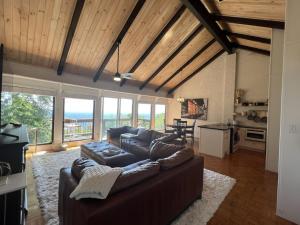 a living room with a leather couch and a table at Remarkable Mountain Escape! Breathtaking Views & Pet Friendly! in Hillsville