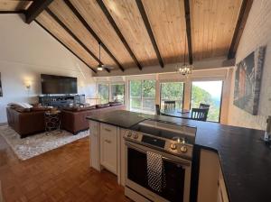 a kitchen with a stove and a living room at Remarkable Mountain Escape! Breathtaking Views & Pet Friendly! in Hillsville