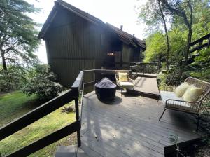a wooden deck with two chairs and a house at Remarkable Mountain Escape! Breathtaking Views & Pet Friendly! in Hillsville
