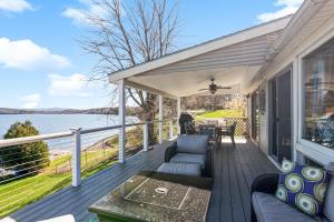a porch with a couch and a table and a view of the water at Lakeshore Vermont in Colchester