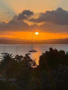 a sunset over the water with boats in the water at Studio with amazing views in Russell