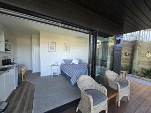 a room with a bed and two chairs at Studio with amazing views in Russell