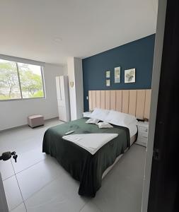 a bedroom with a large bed and a window at alojamientos la martina in Cali