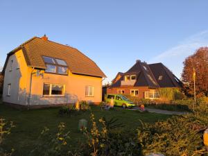 a house with a green car parked in a yard at Pension Feuerschiff in Borkum