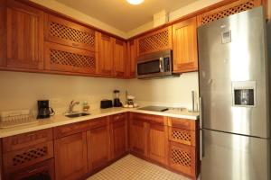 a kitchen with wooden cabinets and a stainless steel refrigerator at Las Clementinas in Panama City